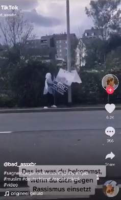 Kopftuch-Mohammedanerin reißt ein PRO-Remscheid-Wahlplakat ab.